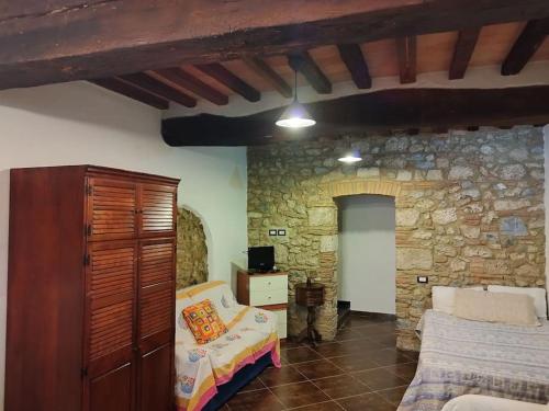 ein Wohnzimmer mit einer Steinmauer in der Unterkunft La taverna sotto la torre in Massa Marittima