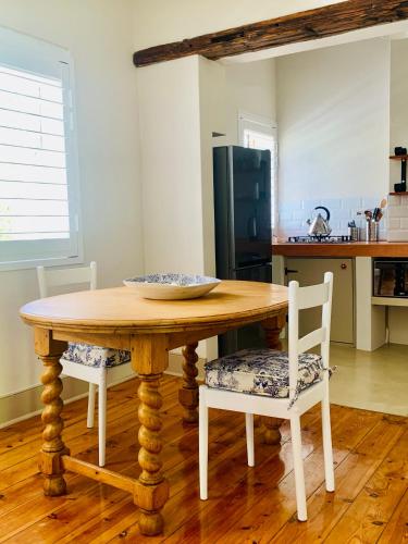 a wooden table with two chairs and a kitchen at Vergeet-My-Niet in Prince Albert