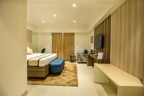 a hotel room with a bed and a television at The Thane Club in Thane