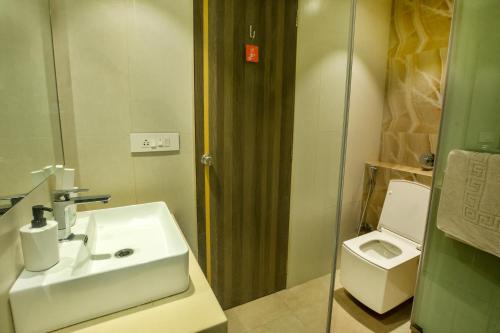 a bathroom with a sink and a toilet at The Thane Club in Thane