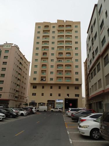 a parking lot in front of a large building at بناية يا هلا in Ajman 