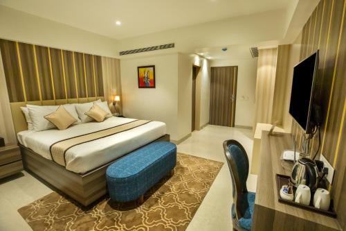 a hotel room with a bed and a tv at The Thane Club in Thane