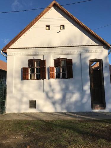 a white house with windows and a door at Feked Farmstay in Feked