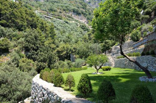 a garden with trees and a stone wall at Casa Angelina in Praiano