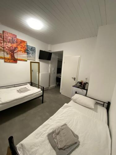 a room with two beds and a television in it at 4-Jahreszeiten FeWo im Herzen Montabaur in Montabaur