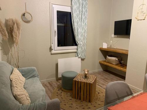 ein Wohnzimmer mit einem Sofa und einem Fenster in der Unterkunft La petite halte in Lemberg