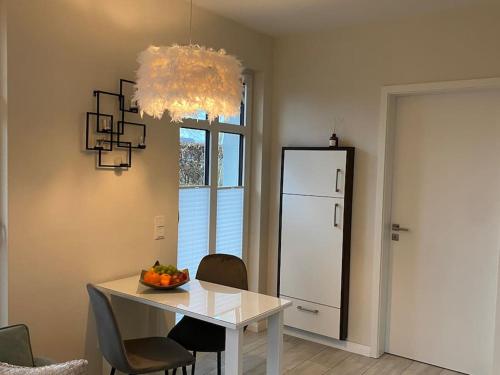 a dining room with a table and a refrigerator at Schöne Ferienwohnung im Ergeschoss mit Terrasse in Ahaus