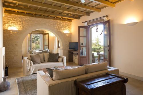 a living room with a couch and a table at Kapsaliana Village Hotel in Kapsalianá