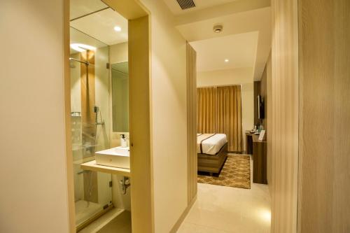 un bagno con lavandino e un letto in una camera di The Thane Club a Thane
