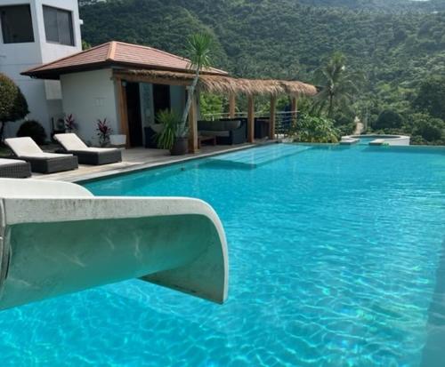 a large blue swimming pool next to a building at Villa Lulu Koh Samui in Mae Nam