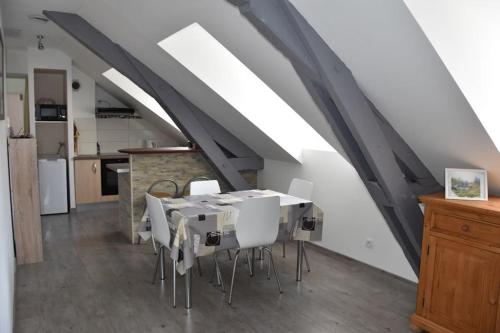 - une salle à manger mansardée avec une table et des chaises dans l'établissement Appartement dans Résidence ( parc thermal Argeles Gazost), à Argelès-Gazost