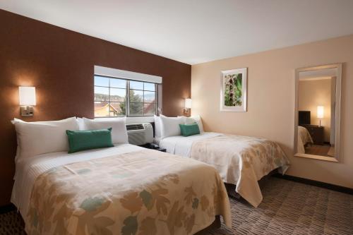 a hotel room with two beds and a window at GreenTree Suites Eagle / Vail Valley in Eagle