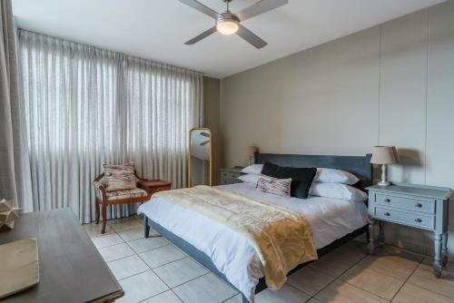 um quarto com uma cama e uma ventoinha de tecto em Lovely 3 Bedroom apartment in the heart of Sandton 505 em Joanesburgo