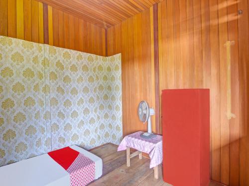 Habitación con cama y mesa con lámpara. en SPOT ON 91799 Sosonopan Homestay, en Manado