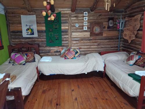 Habitación con 3 camas en una cabaña de madera en Quinta Los Olivos en Maipú
