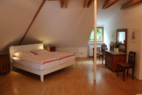 Schlafzimmer mit einem Bett und Holzboden in der Unterkunft Wohnung mit Dachterrasse in Starnberg in Starnberg