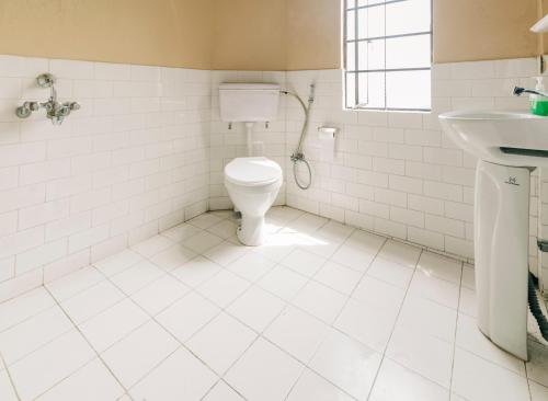 a bathroom with a toilet and a sink at Cloud 9 - B&B in Kalimpong