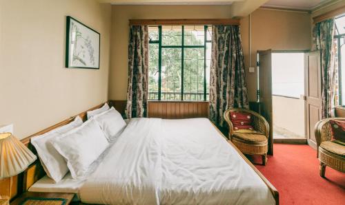 a bedroom with a large bed and a window at Cloud 9 - B&B in Kalimpong