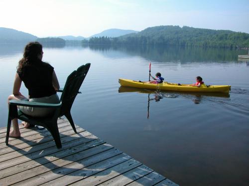 a woman and two children in a kayak on a lake at Le Grand Lodge Mont Tremblant in Mont-Tremblant