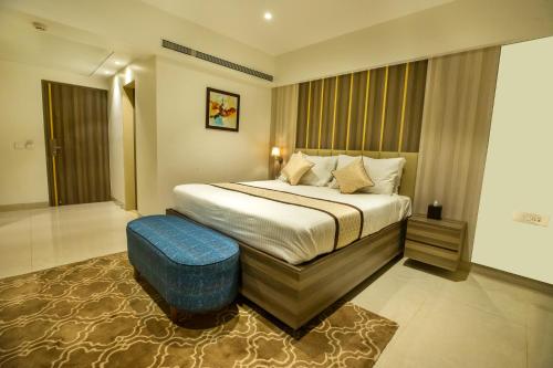 a hotel room with a bed and a blue stool at The Thane Club in Thane
