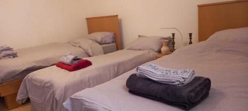 a bedroom with two beds with towels on them at Lazarus Guest House in Abū Dīs