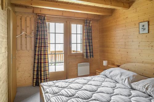 um quarto com uma cama grande num quarto de madeira em Fata Morgana 6 em Bettmeralp