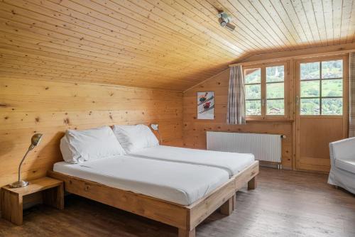 1 dormitorio con 1 cama en una habitación de madera en Tio Pepe OG, en Fiesch