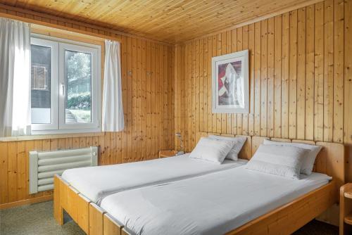 um quarto com uma cama numa parede de madeira em Lotus OG em Fiesch