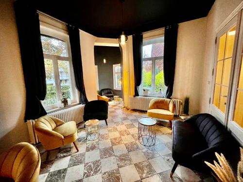 a living room with couches and chairs and windows at La Villa Blanche Spa in Spa