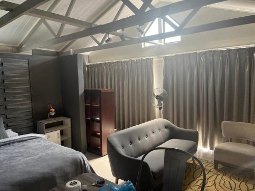 a bedroom with a bed and a chair at 28 on Symonds Luxstudio 5 in George