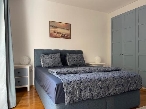 a bedroom with a blue bed with two pillows at Апартамент Старецът и морето in St. St. Constantine and Helena