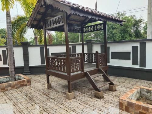 - un banc en bois avec un kiosque sur la terrasse dans l'établissement Homestay Kemaman Private Pool Fyna, à Kampong Kemaman