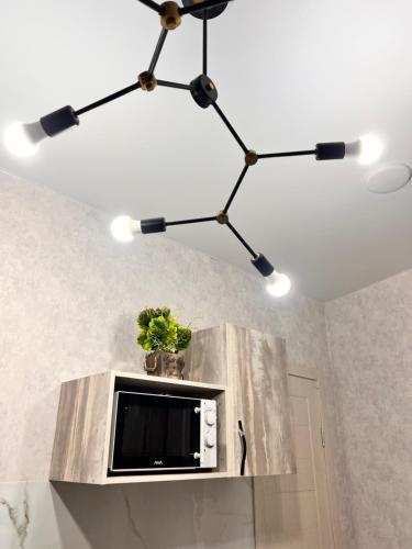a chandelier hanging from a ceiling with a microwave at Sport Hotel Terra in Ustʼ-Kamenogorsk