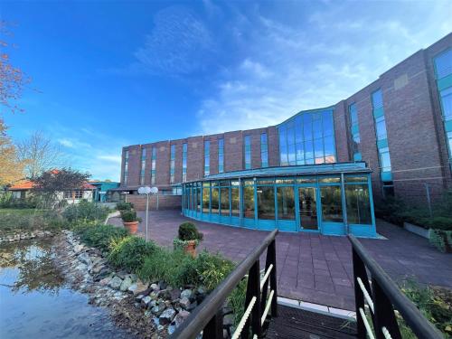 a large building with a blue building and a bridge at Best Western Parkhotel Brehna-Halle in Brehna