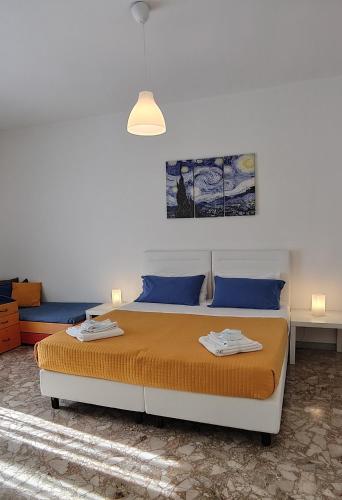 a bedroom with a bed with orange sheets and blue pillows at Klimt-Van Gogh-Dolci Impressioni in Matera