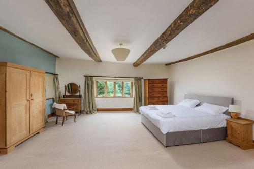 a large bedroom with a large bed and a window at 10 Bed Stunning House in village, with Hot Tub in Ovingham