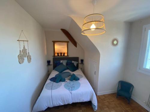 a bedroom with a bed with blue pillows at Les Mouettes in Ouistreham