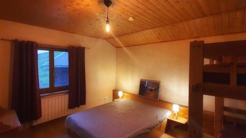1 dormitorio con litera y ventana en Le Chalet de Poche - Gite 2 étoiles - 5 pers en Habère-Poche