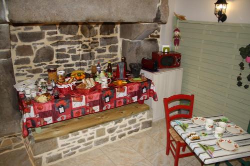 a table in a room with a stone wall at Breizh A-Gevret in Lannion