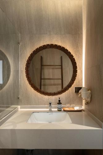 a bathroom with a sink and a round mirror at Ban Saithong Beach Resort in Bang Saphan Noi