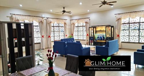 a room with blue chairs and a table and windows at Super Spacious Kuantan Homestay 4R4B by GlimHome in Kuantan