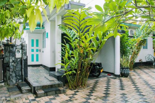 une maison avec des plantes et une moto garée à côté de celle-ci dans l'établissement Villa Harbour View, à Galle