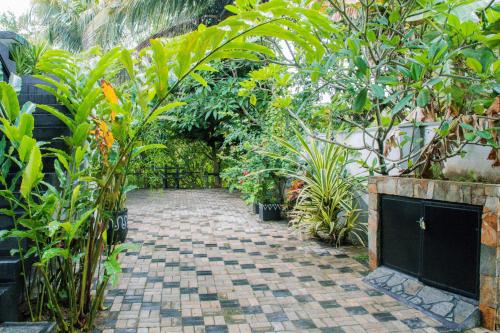 a garden with many plants and a brick walkway at Villa Harbour View in Galle