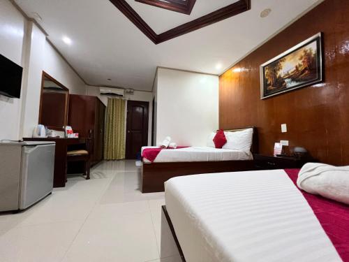 une chambre d'hôtel avec deux lits et une cuisine dans l'établissement Mariafe Inn, à Puerto Princesa