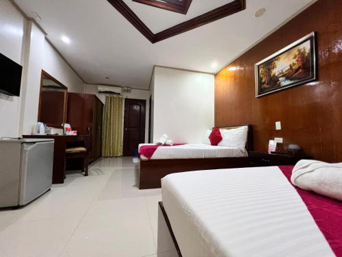a hotel room with two beds and a kitchen at Mariafe Inn in Puerto Princesa City