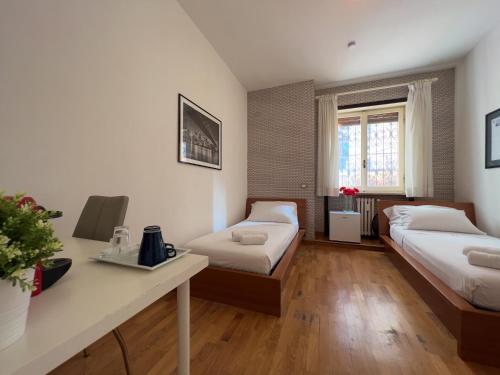 una camera con due letti e un tavolo con fiori di B&B Civico 40 a Milano