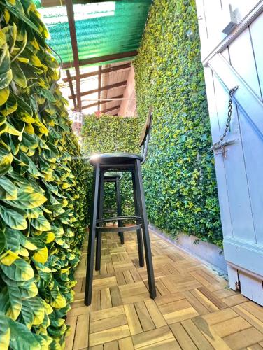a black stool sitting in front of a green wall at Defoy Getaway - Antibes in Antibes