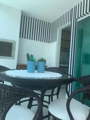 two potted plants on a table on a patio at Encanto dos Mares - Apartamento premium 4 in Camboriú