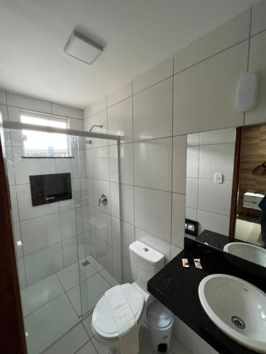 y baño con ducha, aseo y lavamanos. en Hotel Ryad Express, en São Luís
