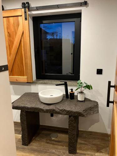 a bathroom counter with a sink and a mirror at Casa da Vinha Escondida AL in Biscoitos